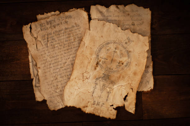 istock Magic scrolls on a wooden table with letters and drawings. 1208374357