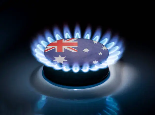 Burning gas burner of a home stove in the middle of which is the flag of the country of Australia. Gas import and export delivery concept, price per cubic meter, transit, background, gasoline
