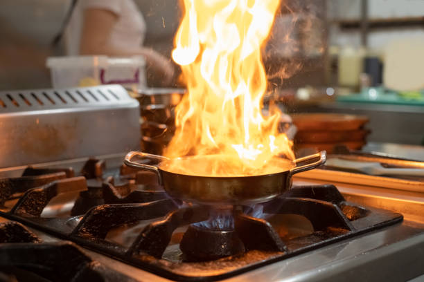 istock cooking with flame in a frying pan on a kitchen stove 1208377304