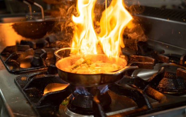 istock cooking with flame in a frying pan on a kitchen stove 1208379020