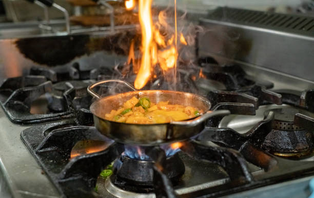 istock cooking with flame in a frying pan on a kitchen stove 1208380035