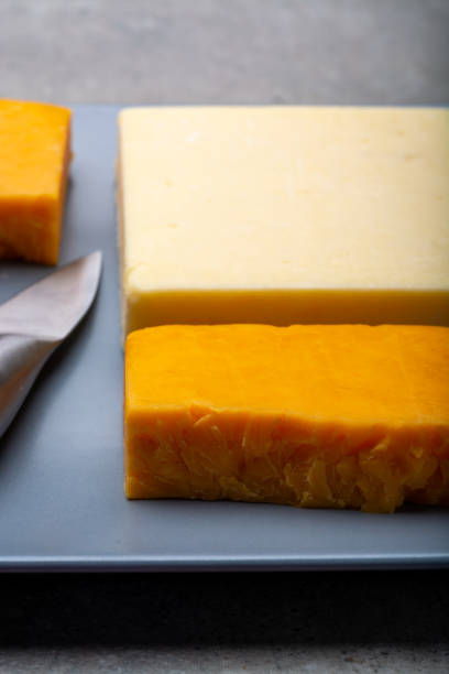istock Cheese collection, matured and orange original British cheddar cheese in blocks served on grey plate 1208380503