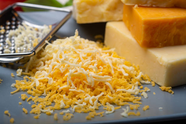 istock Cheese collection, matured and orange original British cheddar cheese in blocks and grated served on grey plate 1208380565