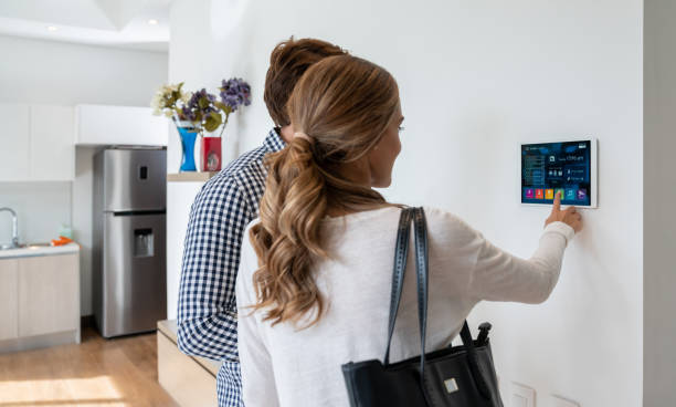istock Back view of latin american couple activating their smart home system 1208382067