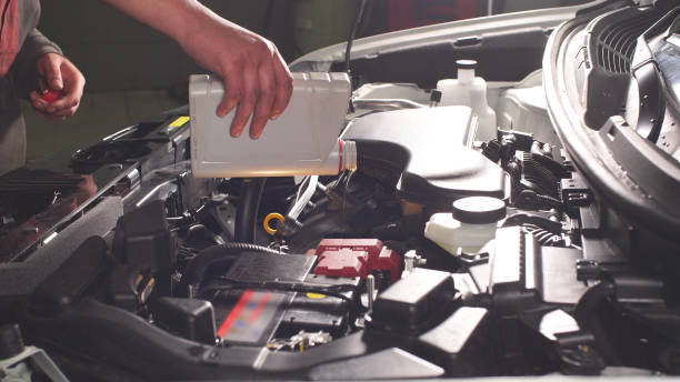 istock Pouring oil to car engine, close up 1208386333