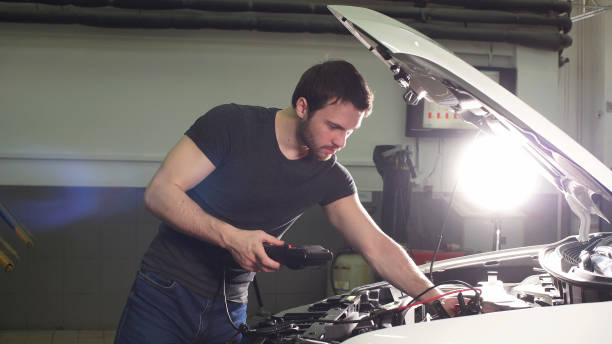 istock Young Technician Man Making Engine Service of Car in Garage 1208386347