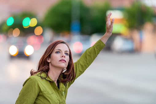 A woman tries to tail a taxi that she's spotted on the street.