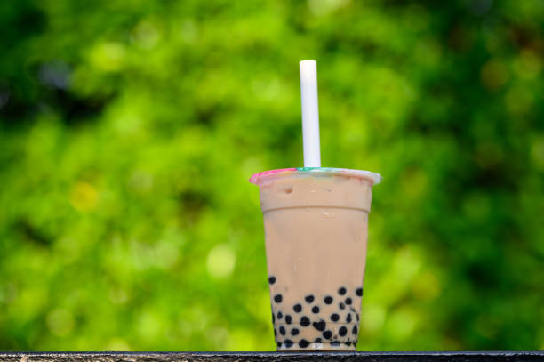 Image of A plastic cup of fresh milk with brown sugar boba drinks with green background
