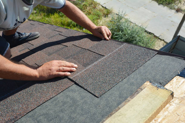 istock Roofer installing asphalt shingles on house construction roof corner. Roofing construction. Roofing contractor install roof tiles. 1208388638