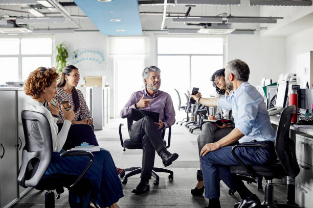 istock Businessman showing smart phone to colleagues 1208388903