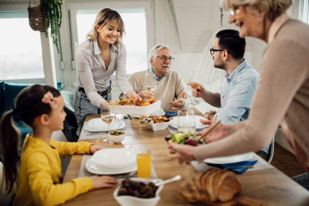 istock Happy extended family enjoying in lunch at dining table. 1208391676