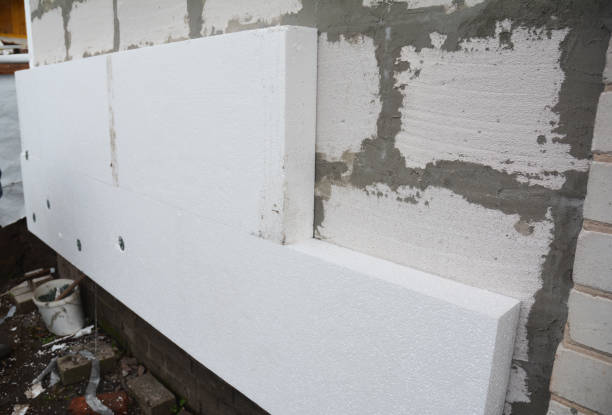 istock Rigid extruded polystyrene house wall insulation. Insulating house aerated concrete blocks wall with rigid styrofoam outdoors. 1208391774