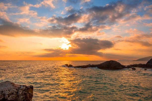 istock Sea Dawn and Pink Clouds on the Rocky Shore 1208392084