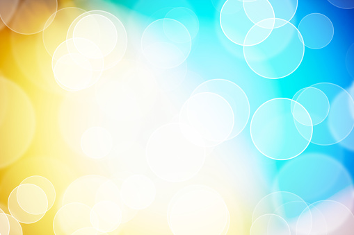 Defocused lights, sparkles, bokeh over colored blue and yellow background