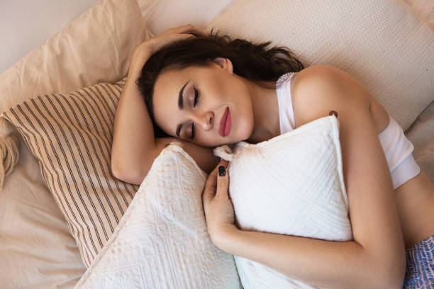 istock Happy sleeping woman embracing pillow 1208392369