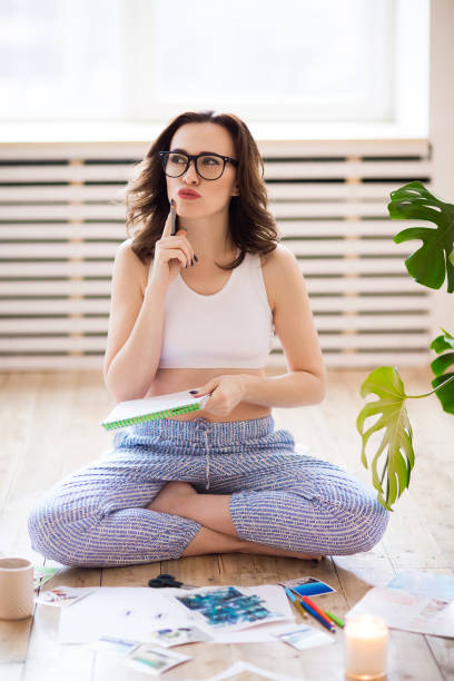 istock Young brunette woman creating her Feng Shue wish map using scissors 1208392699