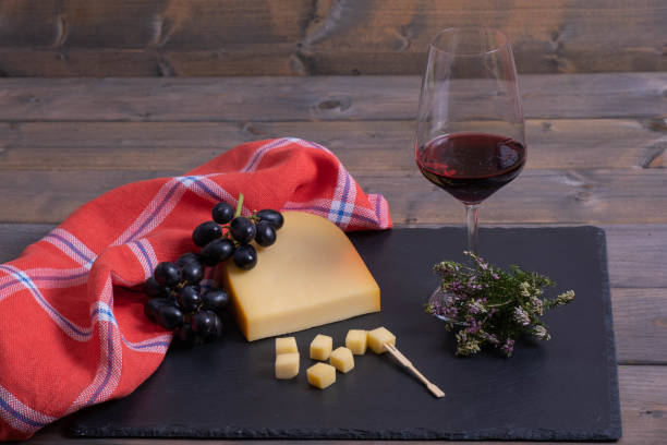 istock cheese, grapes and wine on a stone, on a wooden table. 1208393674