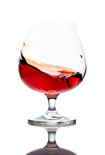istock Splash of cognac in glass, isolated on white. 1208394189