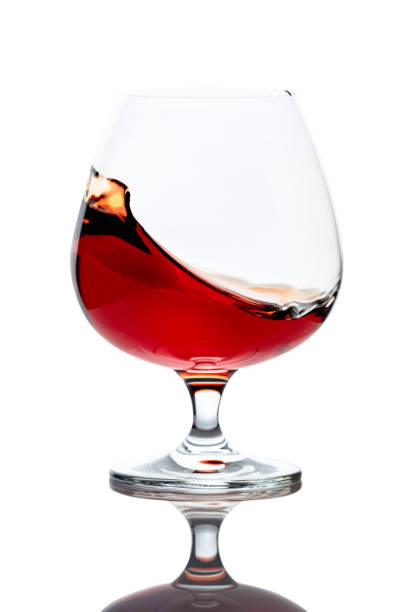 istock Splash of cognac in glass, isolated on white. 1208394211
