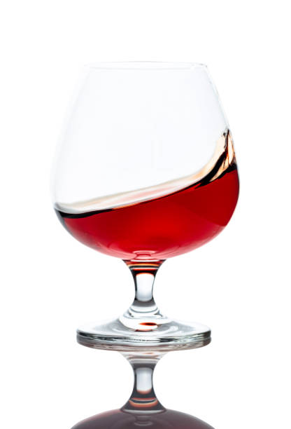 istock Splash of cognac in glass, isolated on white. 1208394212