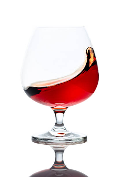 istock Splash of cognac in glass, isolated on white. 1208394224