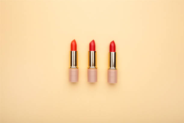 istock Three beautiful red lipsticks on beige background, top view 1208394228
