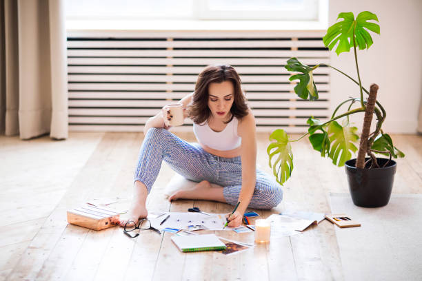 istock Young brunette woman creating her Feng Shue wish map using scissors 1208394416