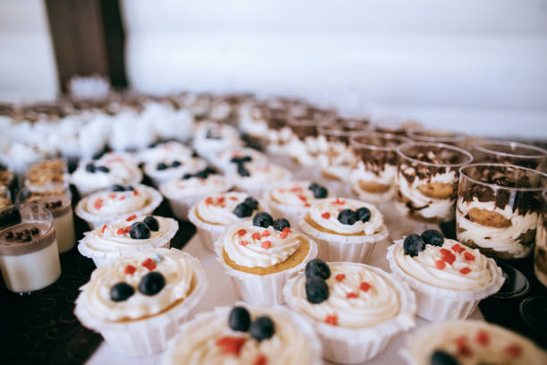 istock Cupcakes with cream and fresh blueberries on a plate on candy bar on party 1208395281