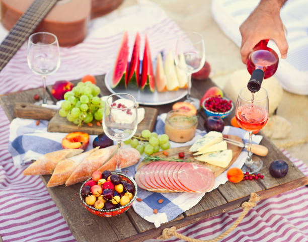 istock Man pouring wine having picnic on beach 1208396180