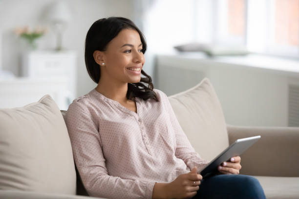 istock African American woman look in distance using tablet 1208397349