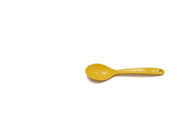 istock A small yellow kids spoon on white isolated background 1208398241