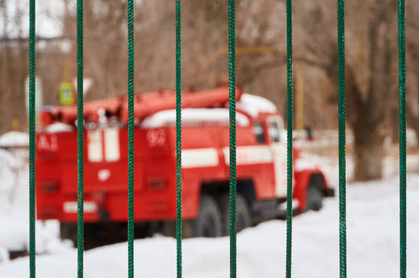 The red fire engine is out of focus behind the iron fence. Abstract background.