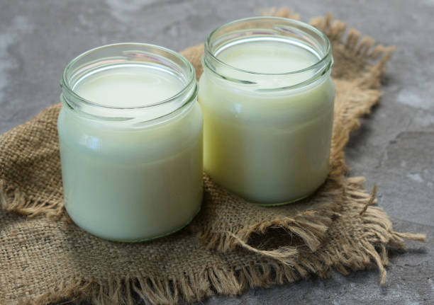 istock Natural yogurt in a jar on a gray background. 1208402064