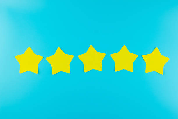 istock five star yellow paper note on blue background with copy space for text. Customer reviews, feedback, rating, ranking and service concept. 1208402130