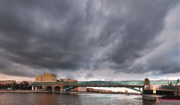 春に劇的な曇り空を動かすガラス橋を持つモスクワの夕日の川 - moscow russia russia river panoramic ストックフォトと画像