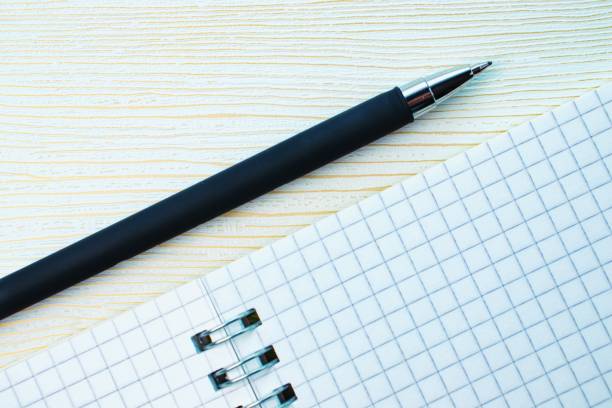 istock Notebook on a spiral and pen on a white background with golden veins. Copy space 1208408386