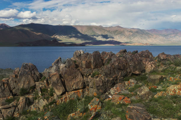 istock Sharp gray stones are covered with moss on the lake in Mongolia. 1208408852