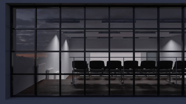 istock Rear View of a Dimly Illuminated Lecture Hall Behind the Windows 1208413533