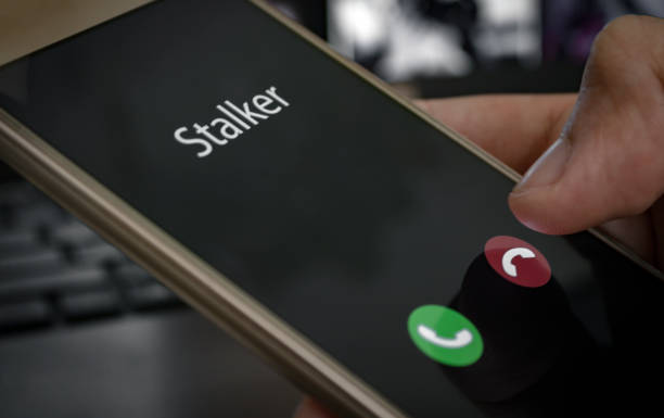 Stalker caller. A man holds a phone in his hand and thinks to end the call. Incoming from an unknown number at work. Incognito or anonymous, scammer or stranger stock photo