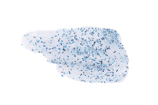 Clear and transparent liquid gel or nail polish smear with blue and silver sparkles isolated on white background with copy space. Top view. Body care spa cosmetic concept. Serum texture.