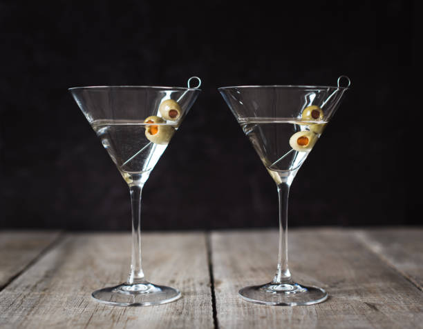 istock Two classic martini cocktails on wood table with black background. 1208417060