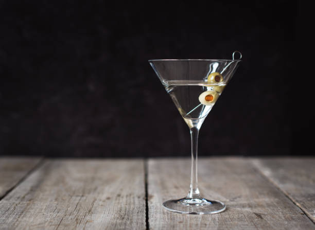 istock Classic martini cocktail on a wooden table with black background. 1208417091