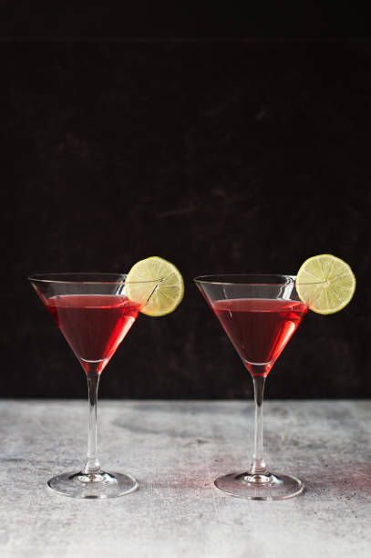 istock Two cosmopolitan martinis on a gray counter with black background. 1208417118