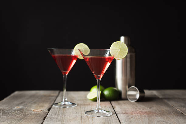 istock Cosmopolitan martini drinks, shaker and limes on a wooden table. 1208417120