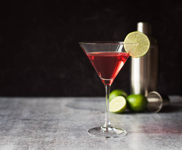 istock Cosmopolitan martini drink, shaker and limes on a gray counter. 1208417123