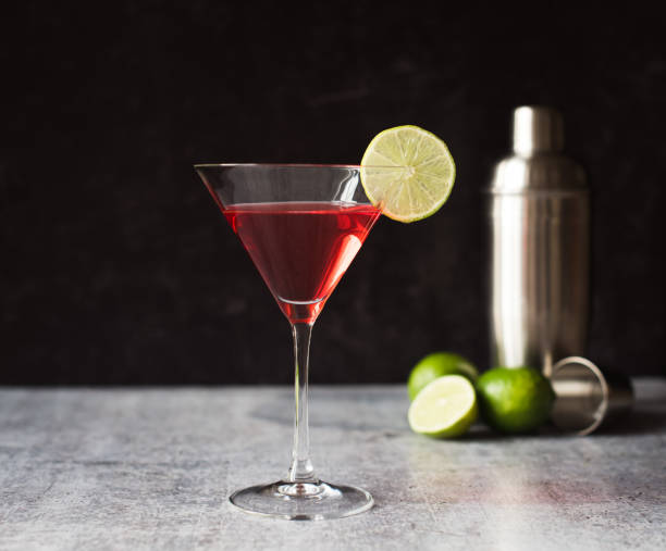 istock Cosmopolitan martini drink, shaker and limes on a gray counter. 1208417131