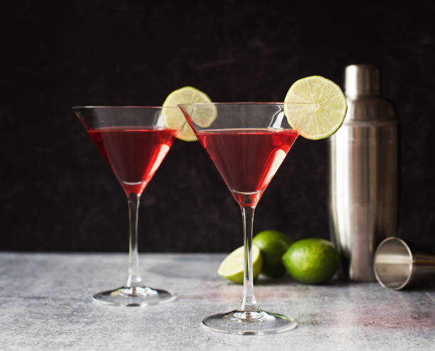 istock Cosmopolitan martini drinks, shaker and limes on a gray counter. 1208417145