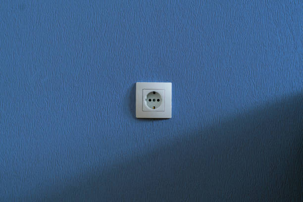 simple single white electricity socket in the wall at home apartment