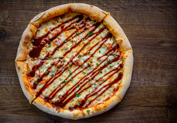 pizza com frango e molho churrasco. pizza italiana em fundo de mesa de madeira - barbecue chicken fotos - fotografias e filmes do acervo
