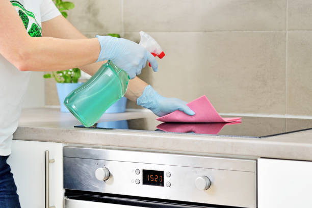 istock Woman in gloves cleaning kitchen. 1208418416